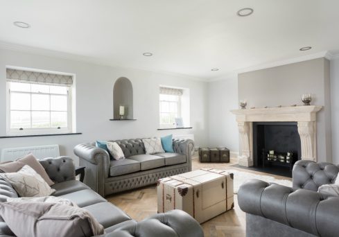 Coastal chic living space with pebble grey painted walls and classic chesterfields